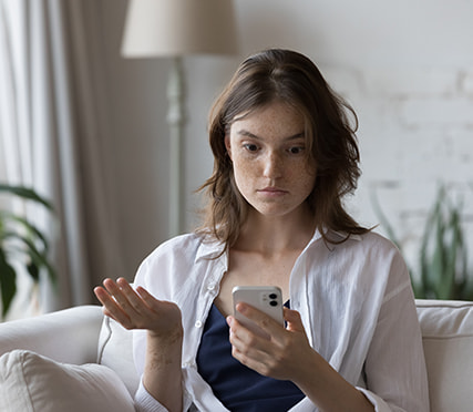 Smartphone met een verdacht WhatsApp-bericht van een onbekend nummer dat zich voordoet als familielid.